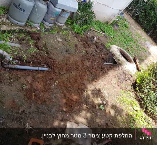 צינור ביוב חשוף באדמה עם מכסה ביוב פתוח